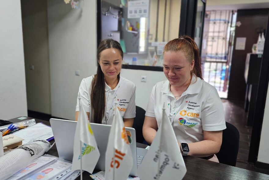 Zwei Helferinnen von CARE sitzen vor einem Laptop