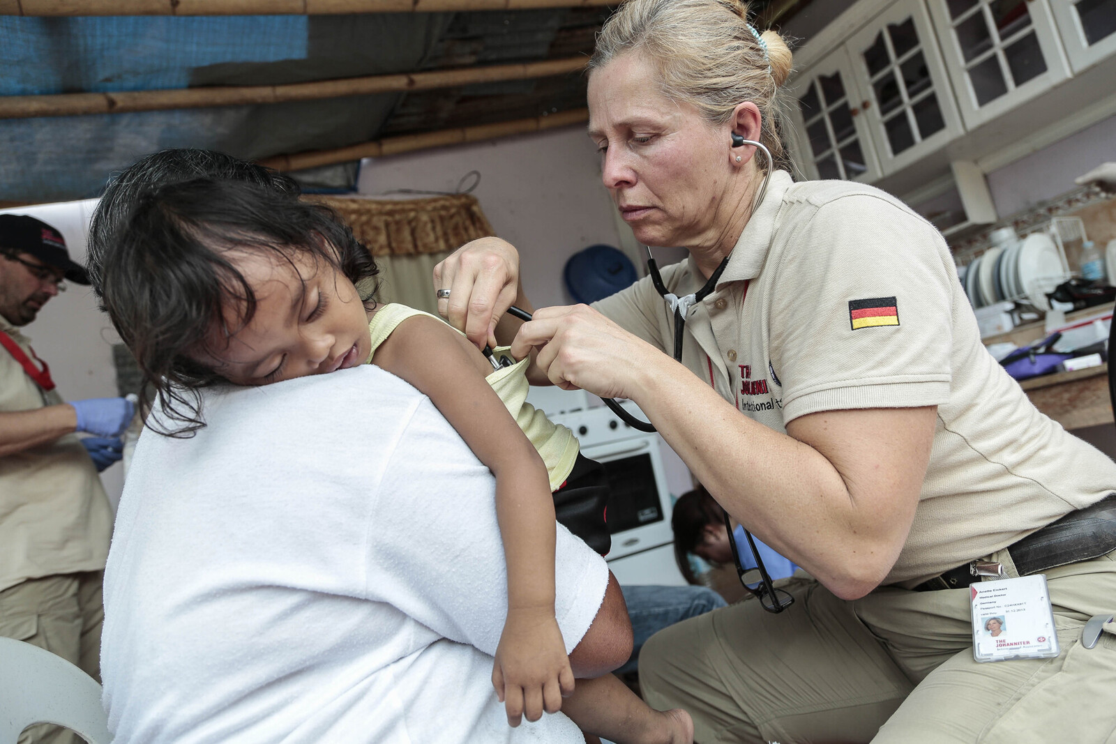 Eine Ärztin untersucht ein Kind auf den Philippinen, nachdem dort ein Wirbelsturm getobt hatte