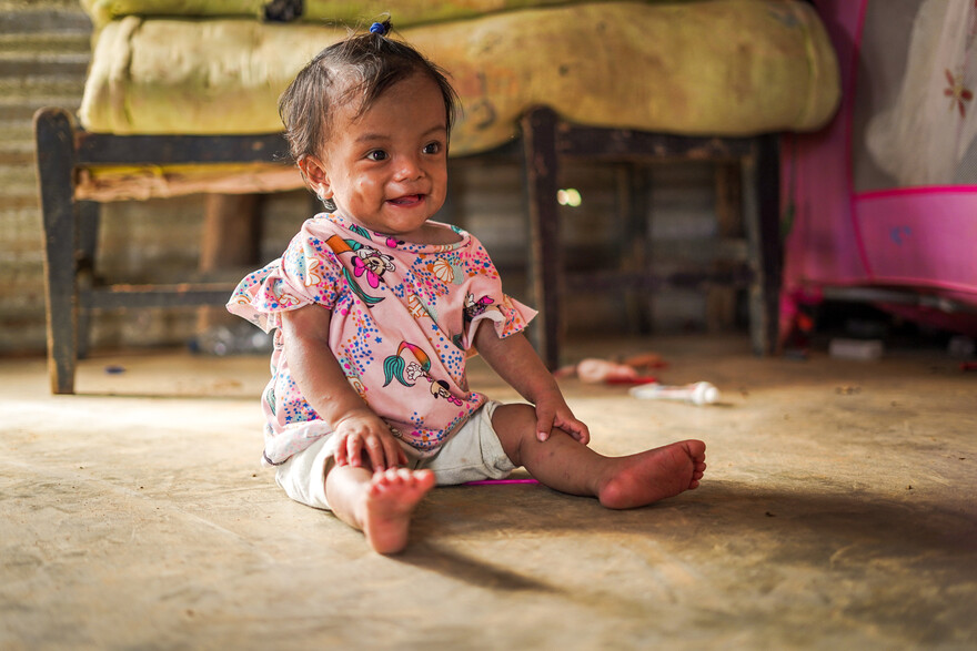 Ein kleines Mädchen aus Kolumbien sitzt auf dem Boden