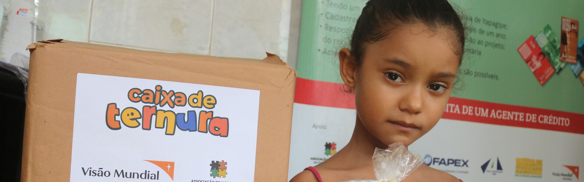 Ein Mädchen in Brasilien hält eine Tüte mit einer Lieferung von der Hilfsorganisation World Vision in der Hand