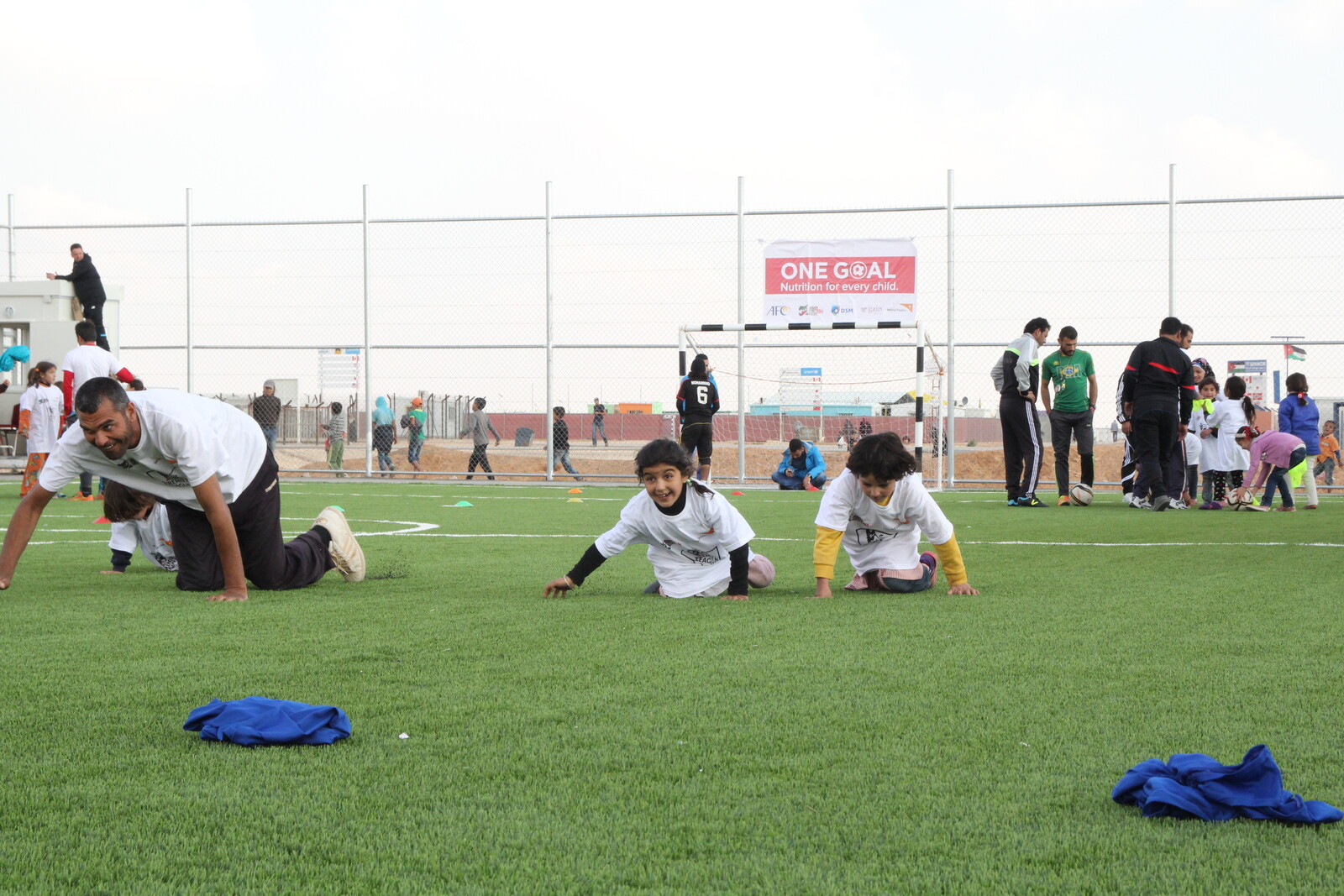 Zwei kleine Kinder toben auf dem Fußballplatz in einem Flüchtlingscamp namens Al Azraq.