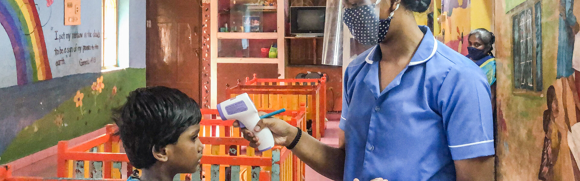 Corona in Indien: Eine Krankenschwester misst Fieber bei einem Kind
