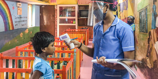 Corona in Indien: Eine Krankenschwester misst Fieber bei einem Kind