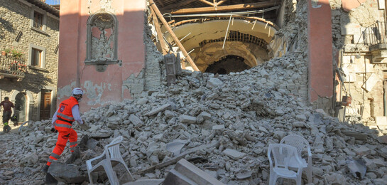 Ein Helfer steigt eine Ruine in Amatrice hoch