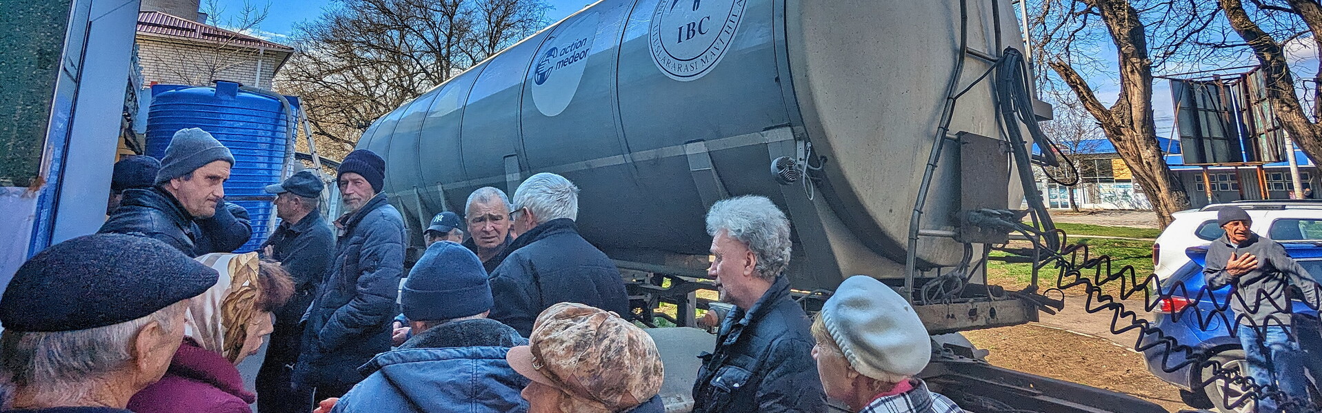 Menschen in Cherson an der Trinkwasserausgabestelle von action medeor und IBC