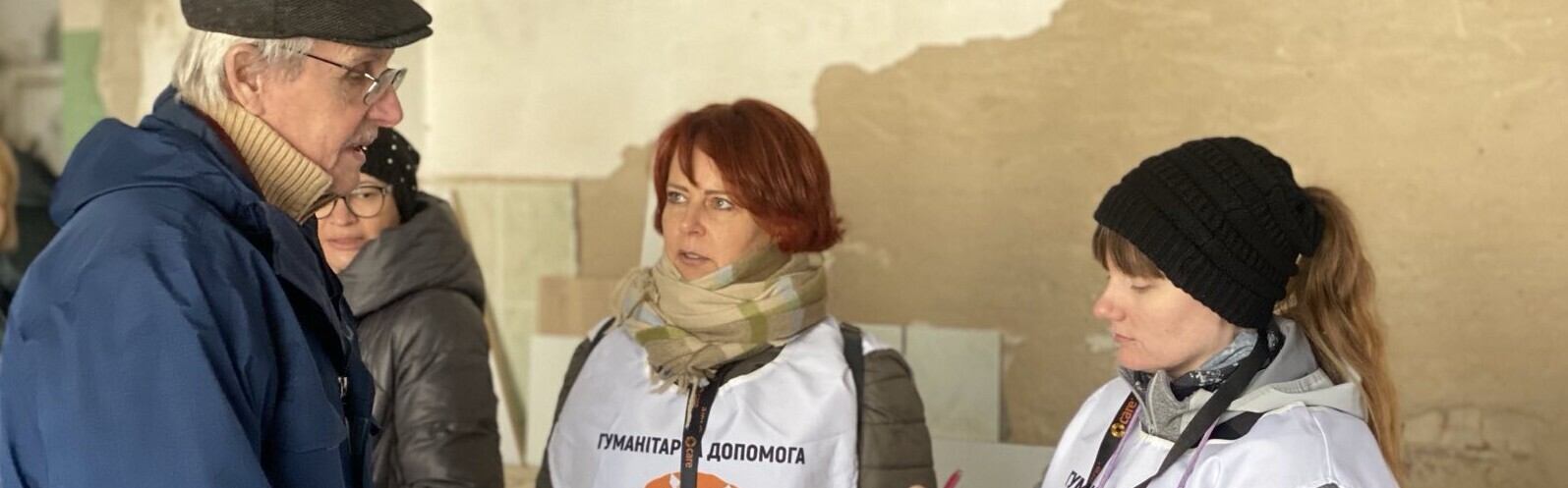 Zwei Helferinnen der Organisation CARE befragen einen ukrainischen Mann