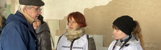 Zwei Helferinnen der Organisation CARE befragen einen ukrainischen Mann
