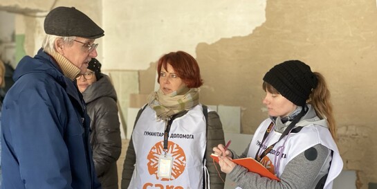 Zwei Helferinnen der Organisation CARE befragen einen ukrainischen Mann
