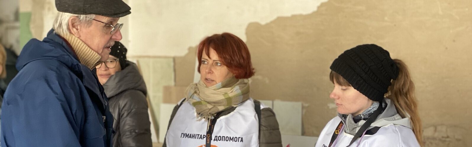 Zwei Helferinnen der Organisation CARE befragen einen ukrainischen Mann