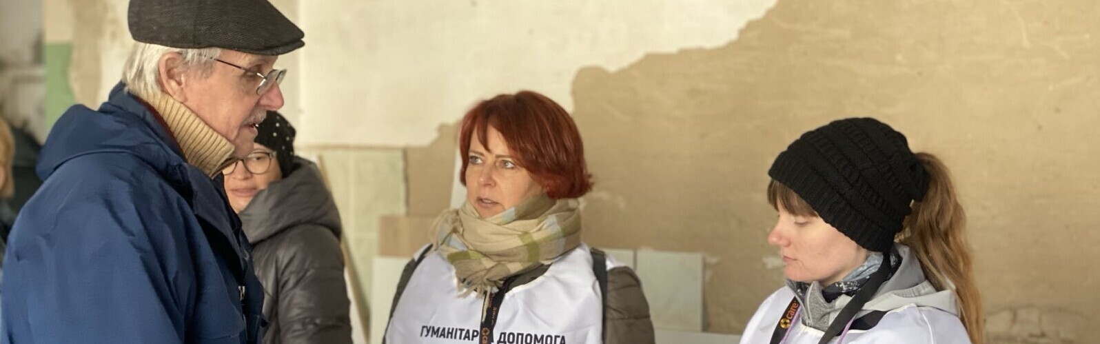 Drei Helferinnen von CARE sprechen mit einem Mann in der Ukraine