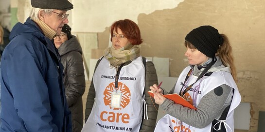 Zwei Helferinnen der Organisation CARE befragen einen ukrainischen Mann