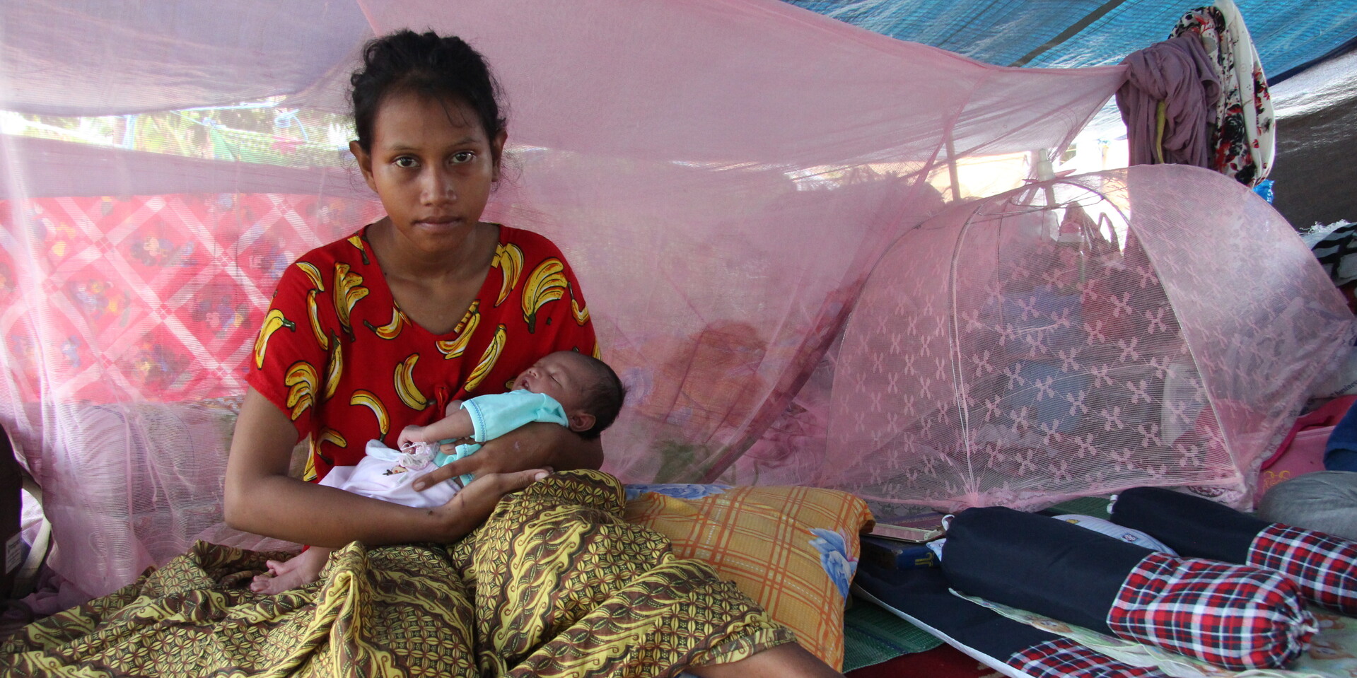 Eine junge Frau aus Indonesien mit ihrem Neugeborenen Eine junge Frau aus Indonesien mit ihrem Neugeborenen