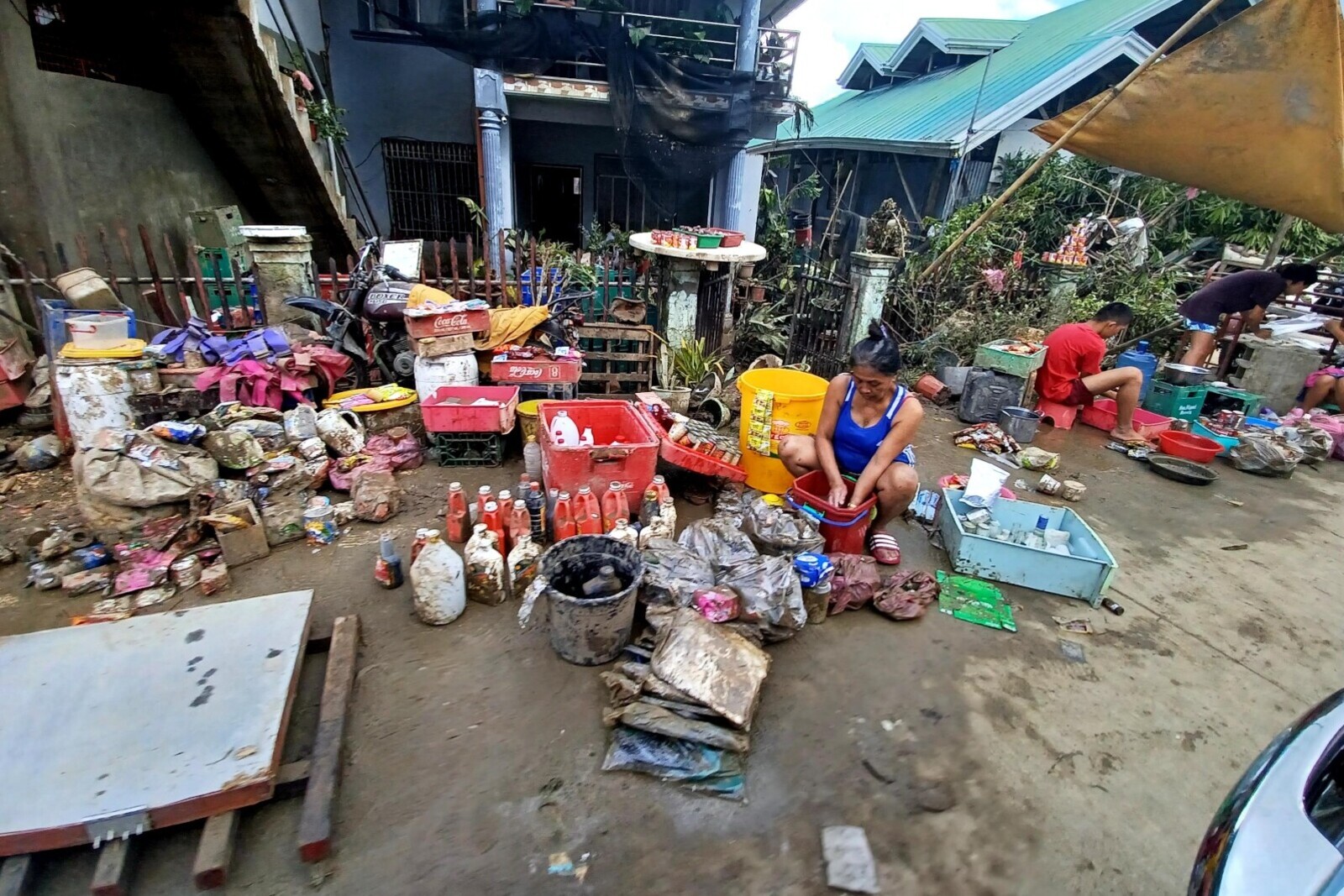 Nach Taifun Rai befreien die Menschen ihr Hab und Gut vom Schlamm