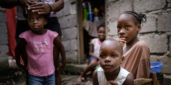 Vier Kinder vor einem Haus in Haiti.