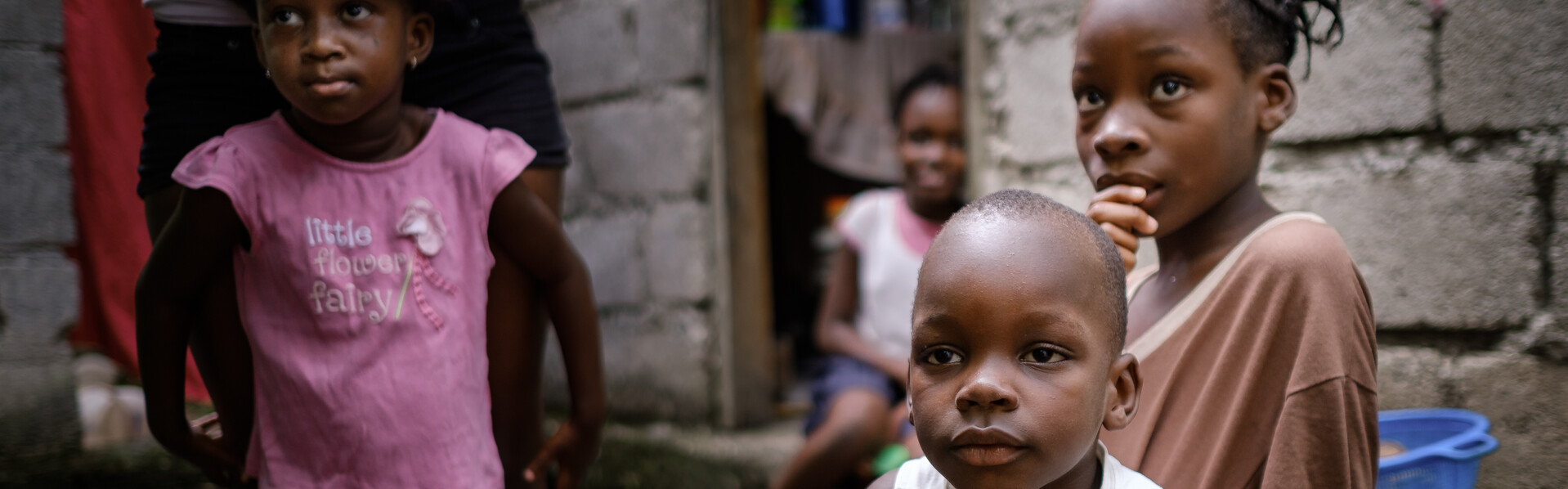 Vier Kinder vor einem Haus in Haiti.