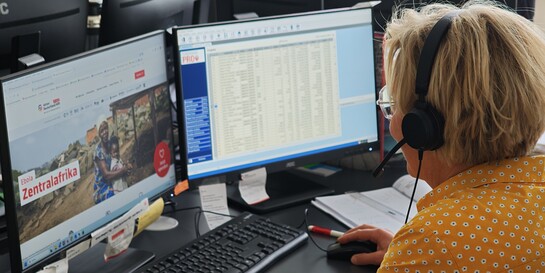Eine Mitarbeiterin von Aktion Deutschland Hilft telefoniert im Spendenservice