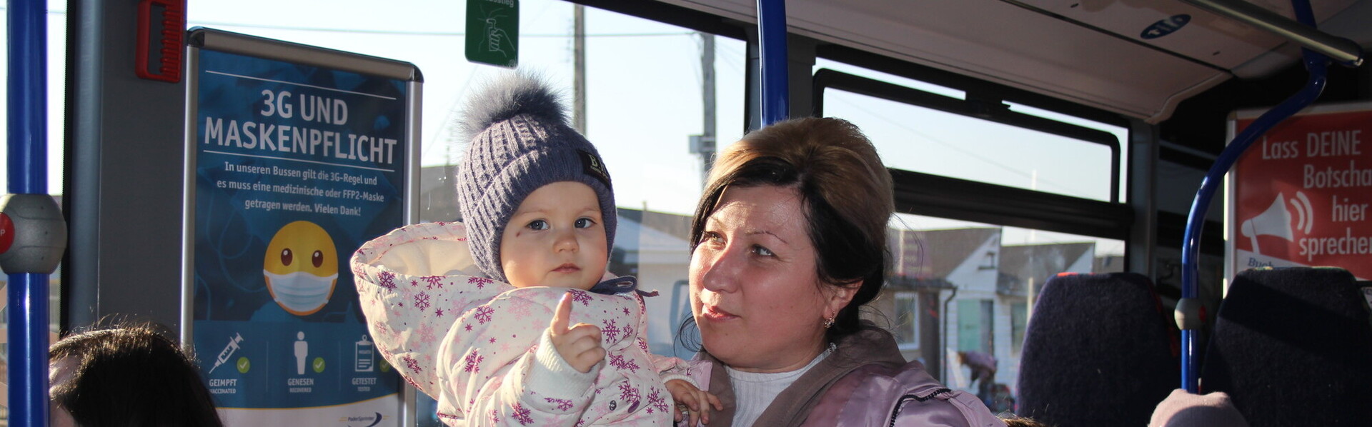 In einem Bus voller Frauen hält eine aus der Ukraine geflüchtete Mutter ihr Kind auf dem Arm