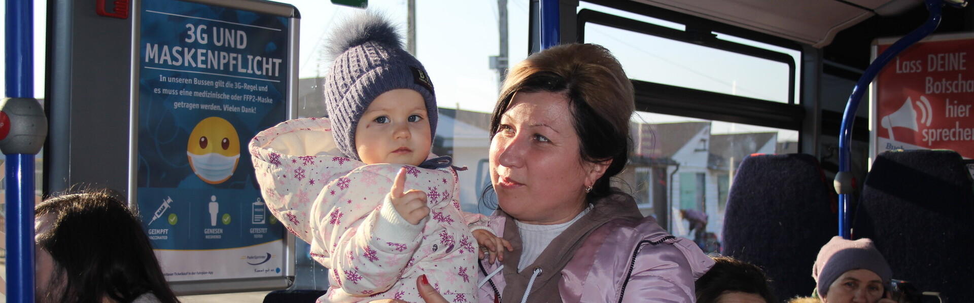 In einem Bus voller Frauen hält eine aus der Ukraine geflüchtete Mutter ihr Kind auf dem Arm