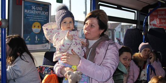 In einem Bus voller Frauen hält eine aus der Ukraine geflüchtete Mutter ihr Kind auf dem Arm
