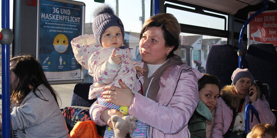 In einem Bus voller Frauen hält eine aus der Ukraine geflüchtete Mutter ihr Kind auf dem Arm