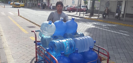 In Ecuador fährt ein Mann Wasserkanister zur Versorgung nach dem Erdbeben herum.