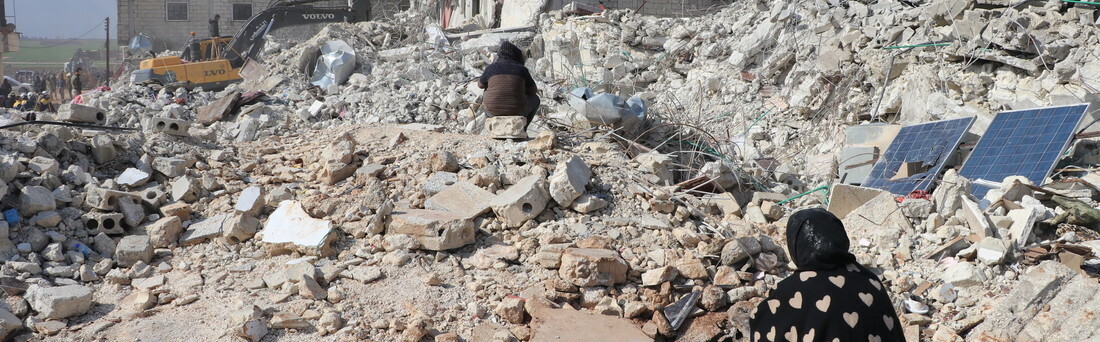 Eine Frau blickt auf die Trümmer nach den schweren Erdbeben in Syrien