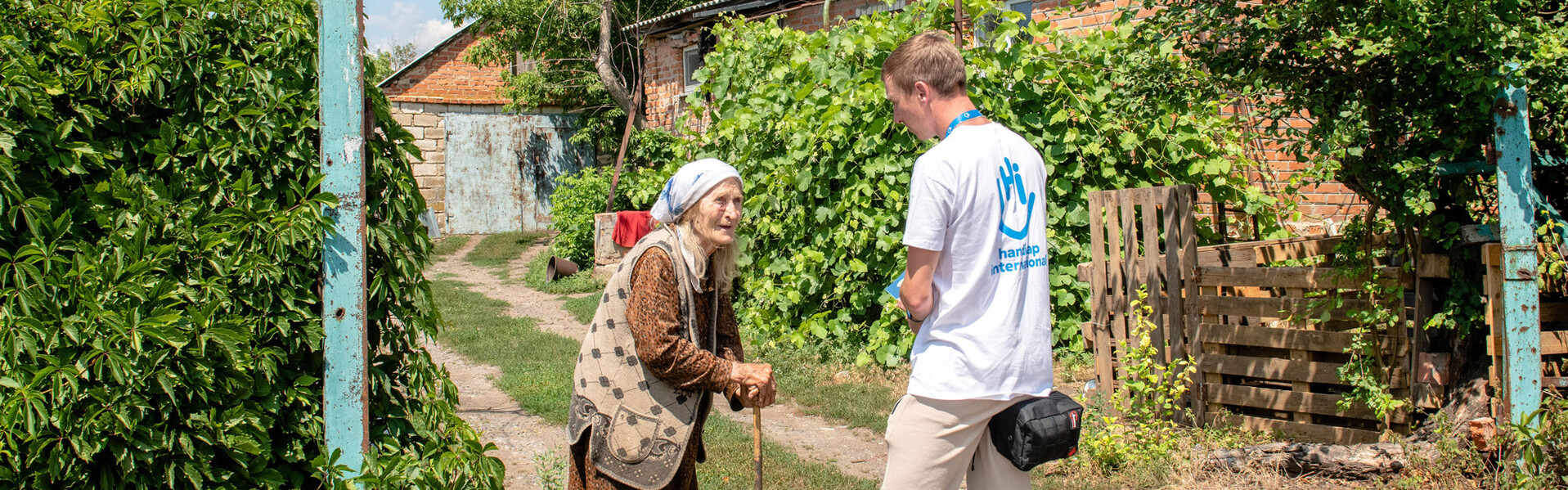 Ein Helfer von Handicap International spricht mit einer älteren Frau