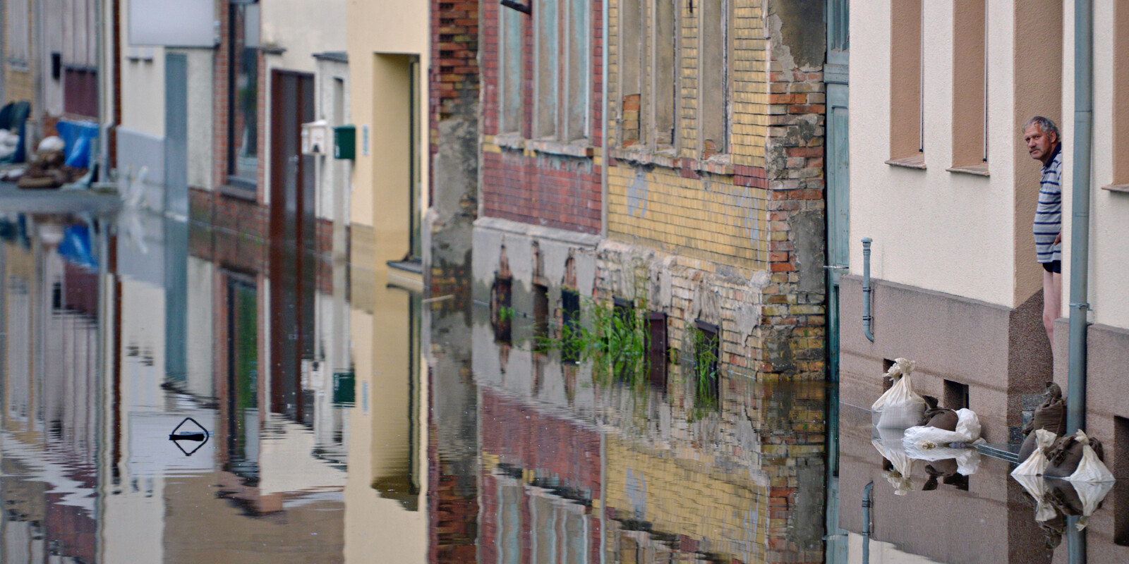 Elbehochwasser: Ein Mann in der Stadt Aken blickt von seiner Haustür auf die überschwemmte Straße 