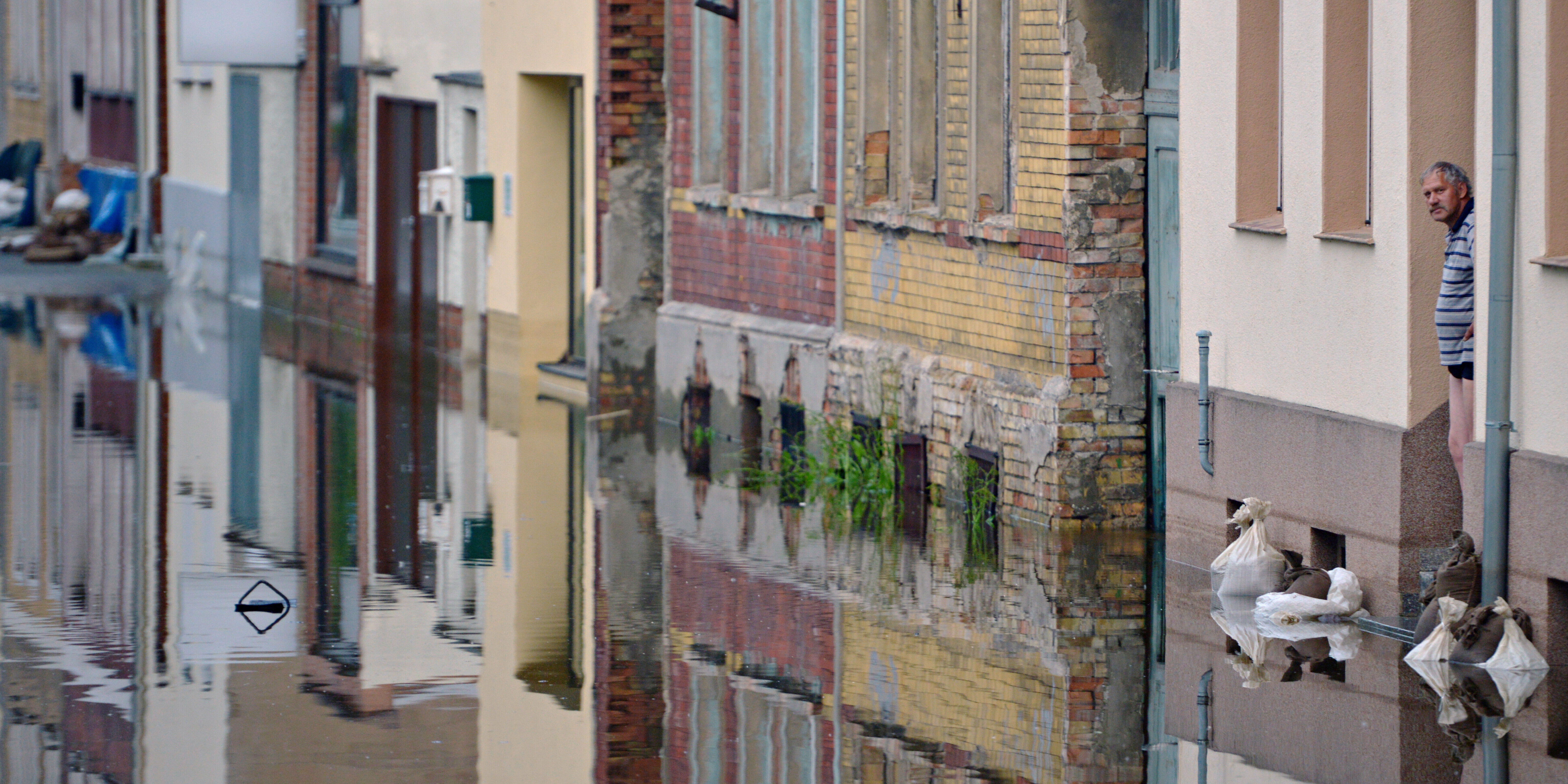 Elbehochwasser: Ein Mann in der Stadt Aken blickt von seiner Haustür auf die überschwemmte Straße Elbehochwasser: Ein Mann in der Stadt Aken blickt von seiner Haustür auf die überschwemmte Straße
