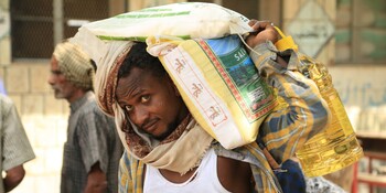 Ein Mann trägt Säcke mit Nahrung nach einer Hilfsgüterverteilung im Jemen Ein Mann trägt Säcke mit Nahrung nach einer Hilfsgüterverteilung im Jemen