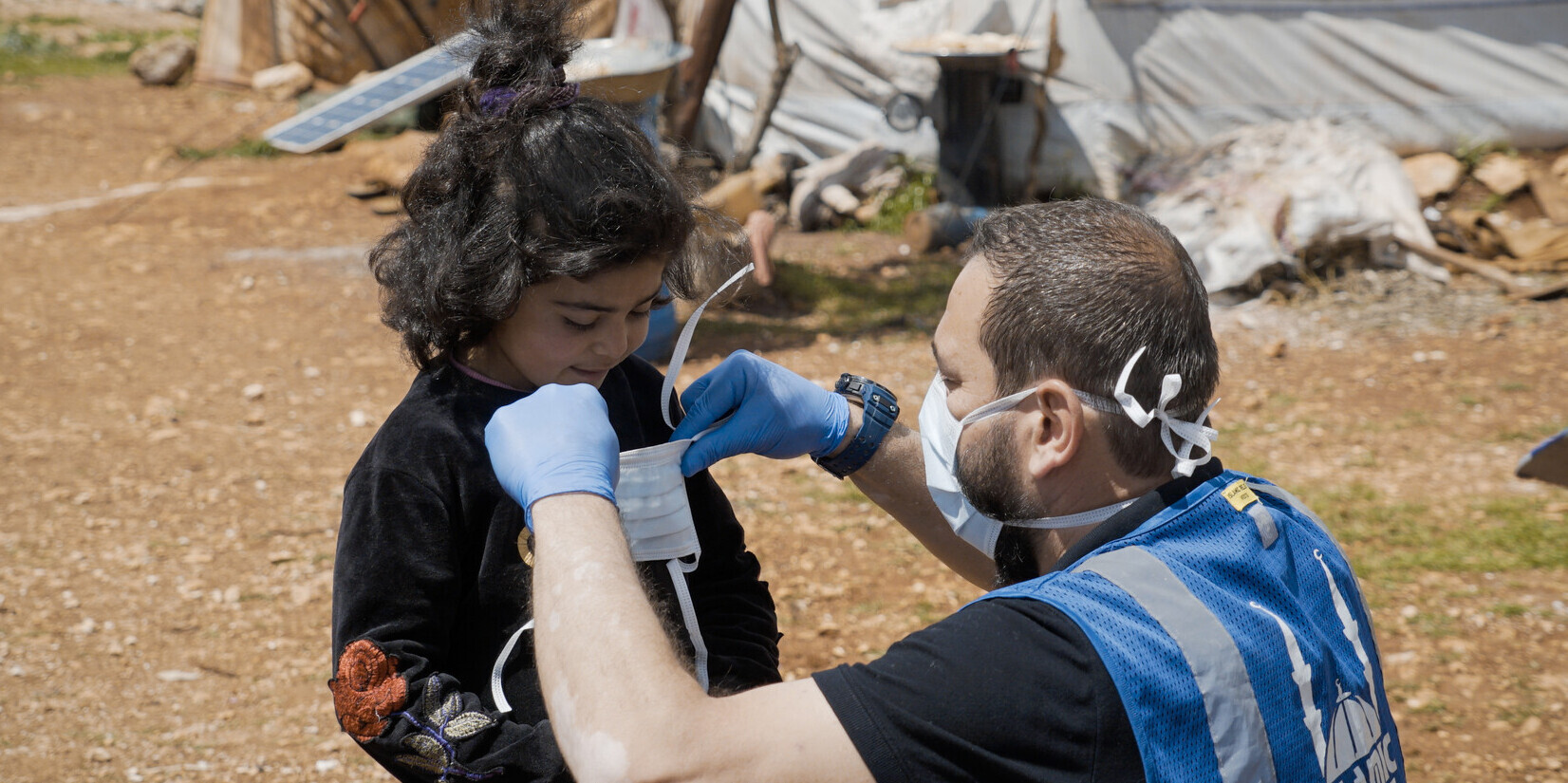 Ein Mädchen und ein Helfer in einem Flüchtlingscamp in Syrien Ein Mädchen und ein Helfer in einem Flüchtlingscamp in Syrien