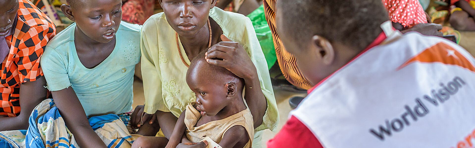 Ein Helfer von World Vision mit Familien im Südsudan
