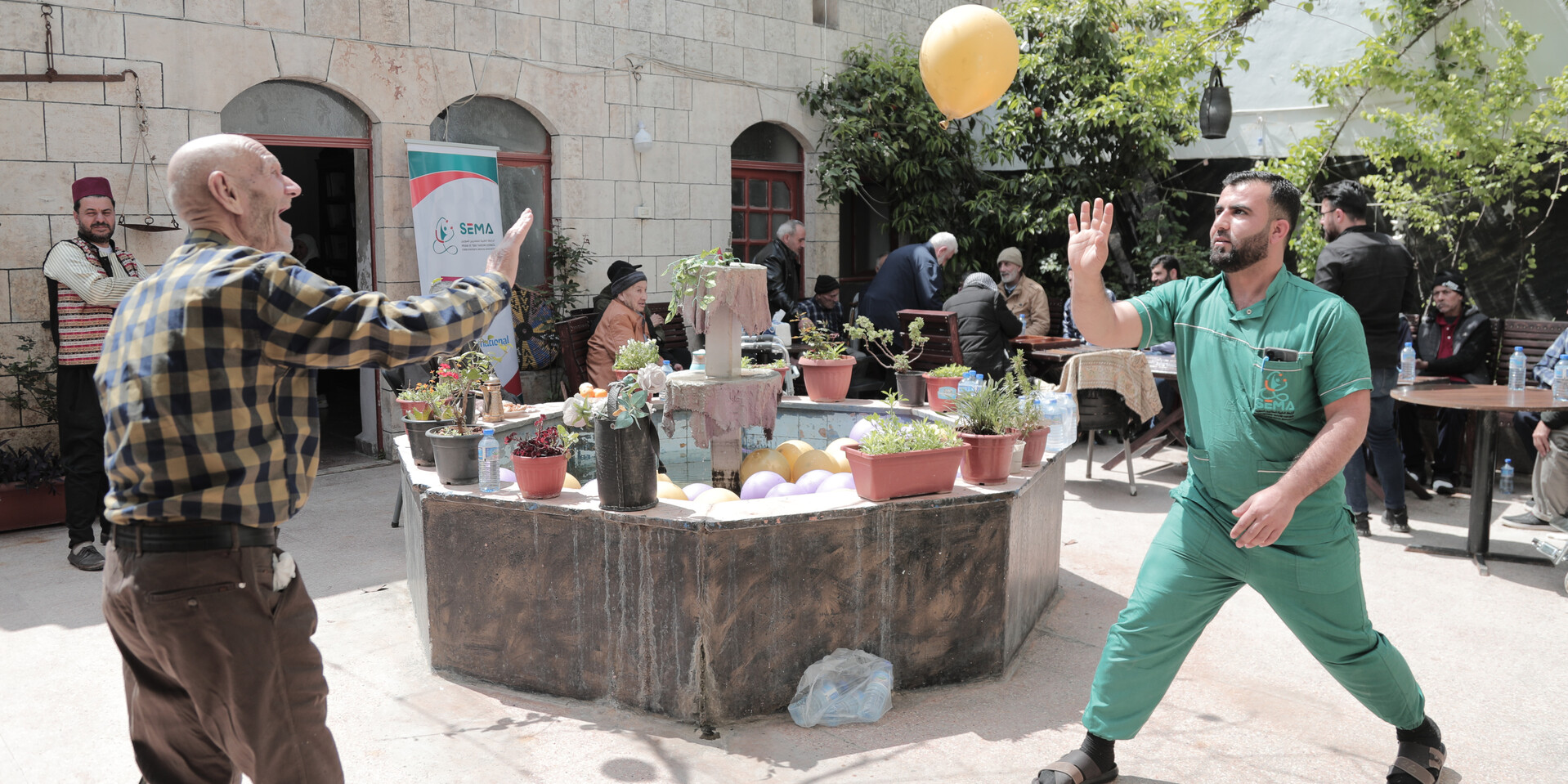 Muhammad und ein Helfer spielen mit einem Luftballon