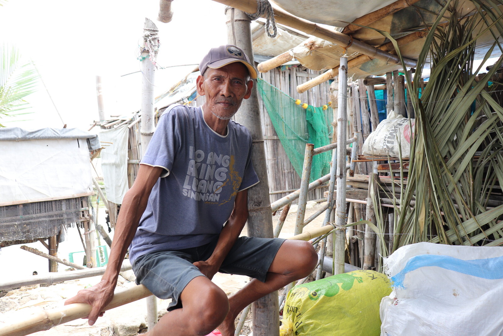 Ernestro Marcial aus Masantol sitzt auf dem Geländer einer schwimmenden Unterkunft