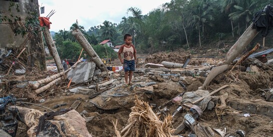  Ein Junge zwischen Trümmern, die die Taifune in Südostasien hinterlassen haben 