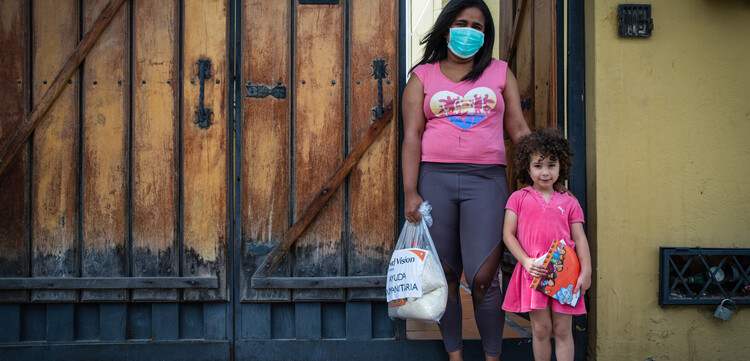 Frau und Kind mit Hilfslieferung in Ecuador