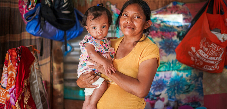 Eine Frau aus Kolumbien hält ein Baby auf dem Arm