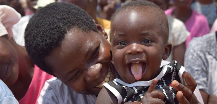 Eine Frau hält in Malawi ein Kind in ihren Armen