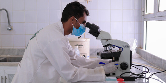 Ein Arzt untersucht im Jemen eine medizinische Probe am Mikroskop