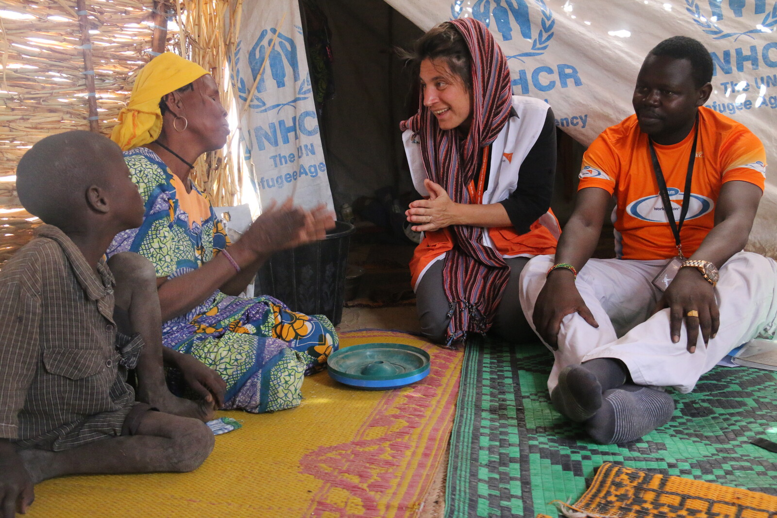 Die Mitarbeiterin einer Bündnisorganisation spricht mit einer geflüchteten Familie aus dem Niger