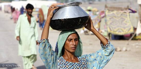 Flut Pakistan: Frau mit Wasser auf dem Kopf