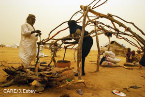 Sudan: Zwei Männer bauen eine Notunterkunft