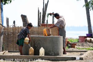 ein Jahr nach dem Zyklon Nargis in Birma: Kind und Mann am Brunnen