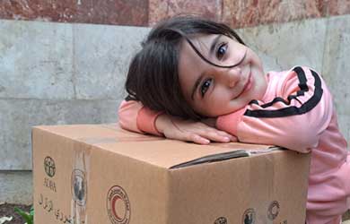 Mädchen aus Syrien freut sich über Hilfspaket